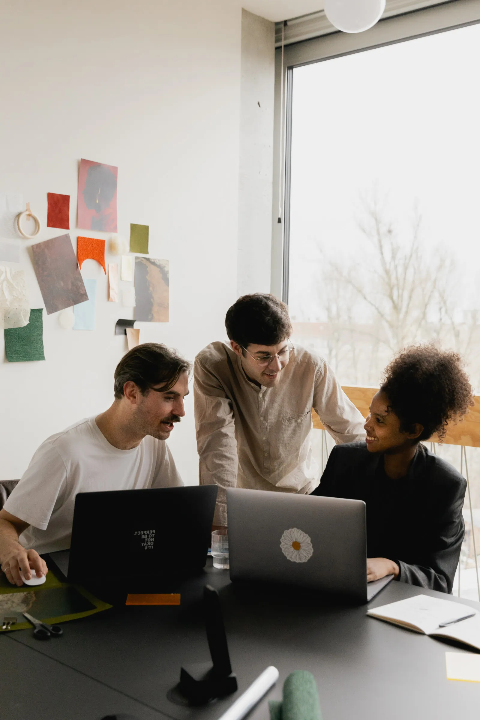Team collaborating around a laptop