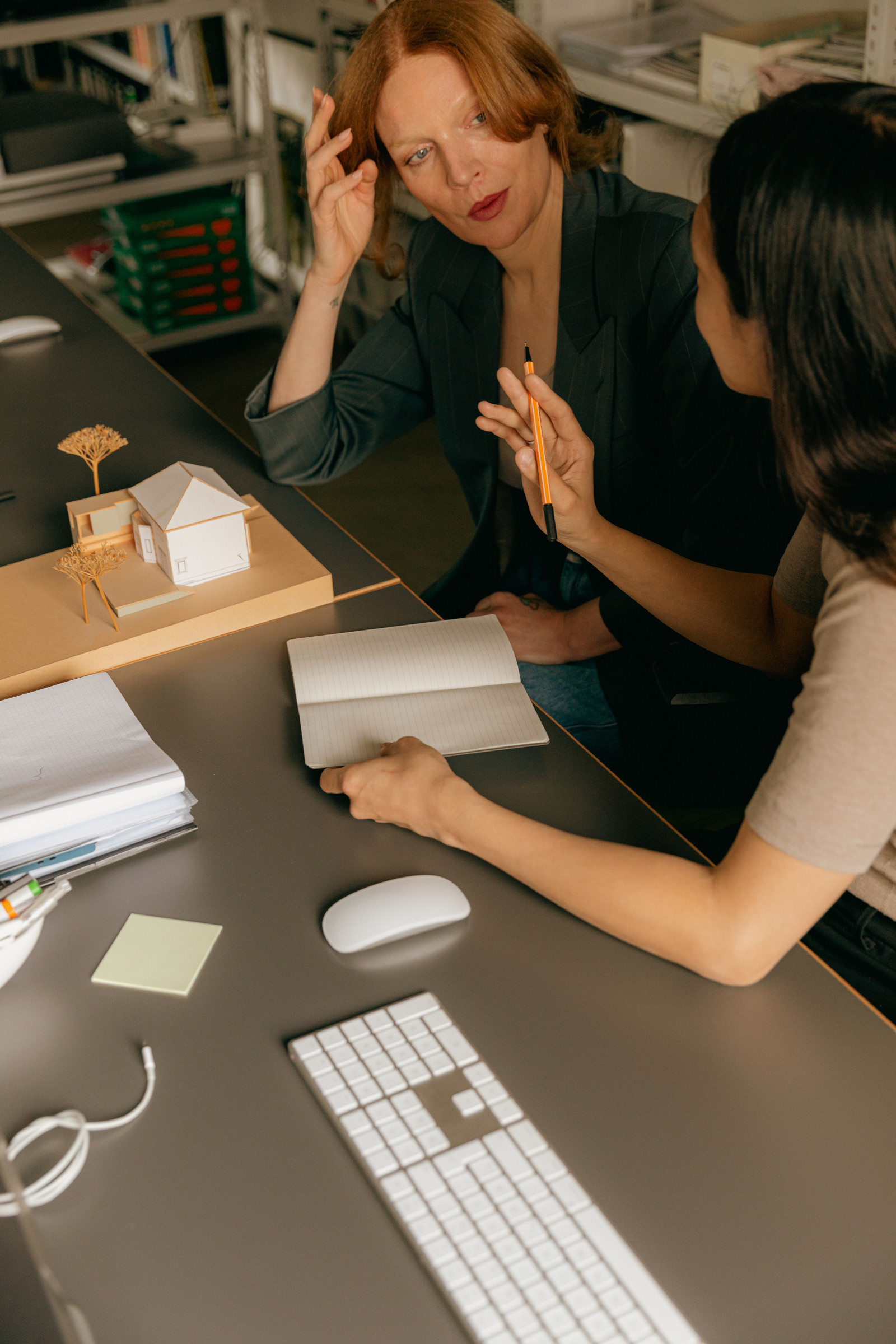 Two professionals collaborating around a model and documents