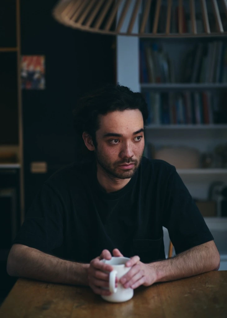 Thoughtful man holding a coffee mug at a wooden table
