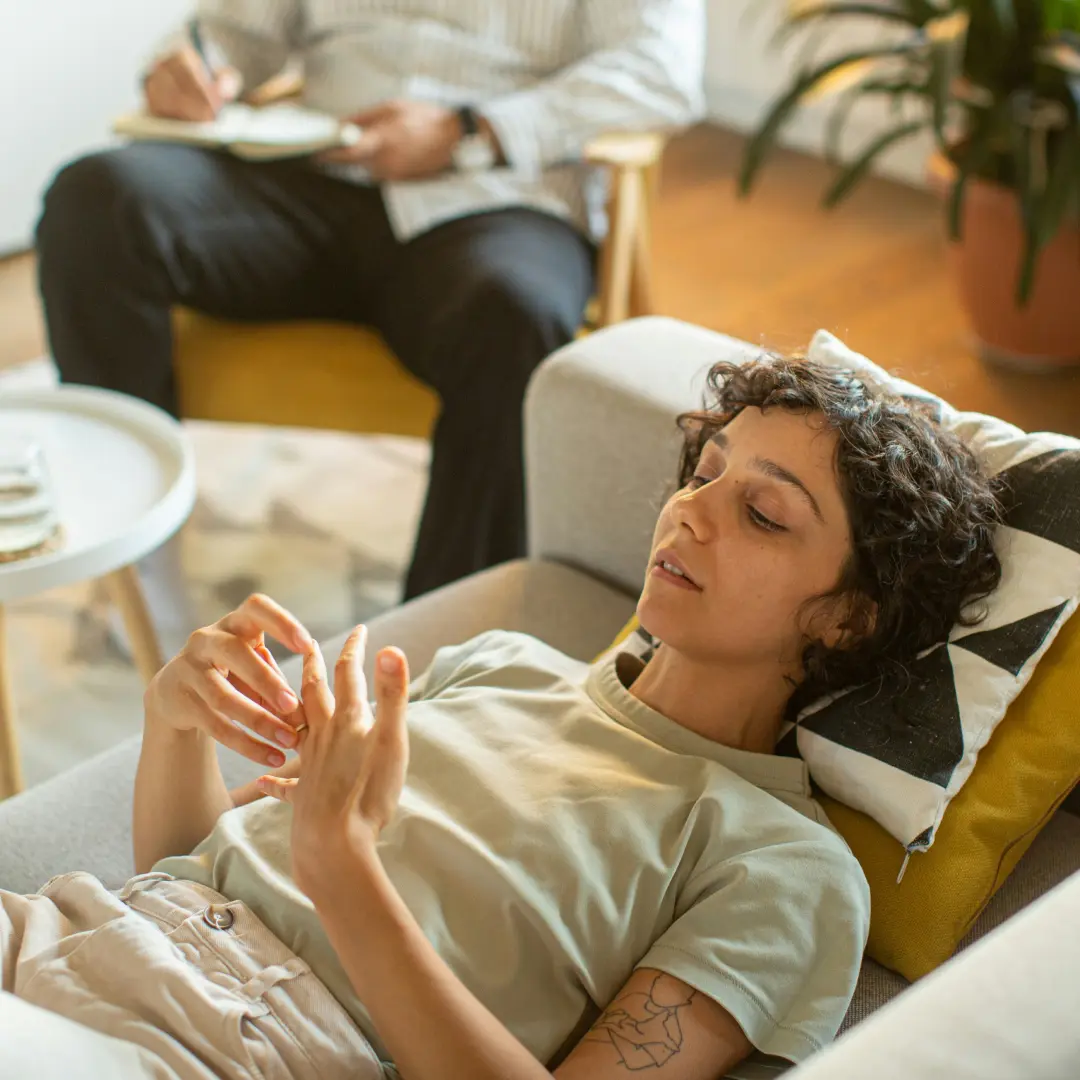 Une femme allongée sur un canapé pendant une séance de consultation.