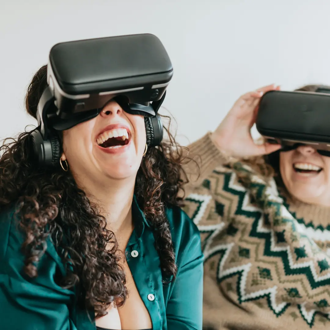 Deux personnes qui rient en portant des casques de réalité virtuelle.