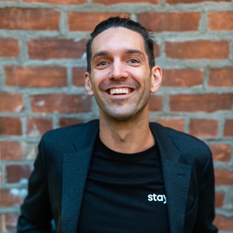 Andrew Lockhead sourit devant un mur de briques.